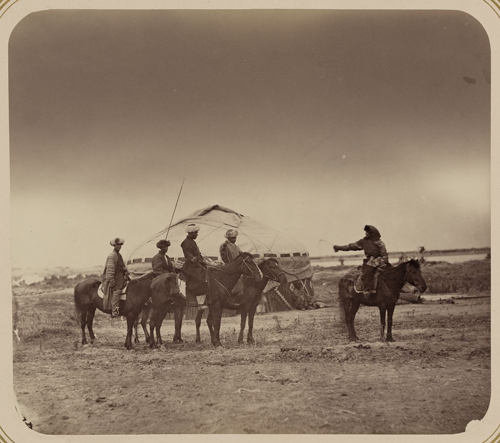 Black and white photograph of people sitting on horses